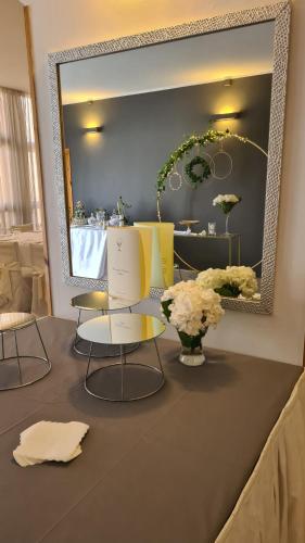a room with two chairs and a mirror and flowers at PEDA Hotel Ristorante Pizzeria in Colletorto