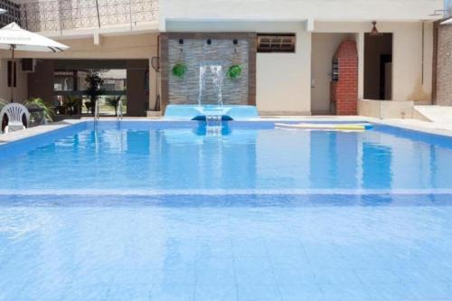 a large blue swimming pool with a fountain at Pousada Villa Goyá in São José da Coroa Grande