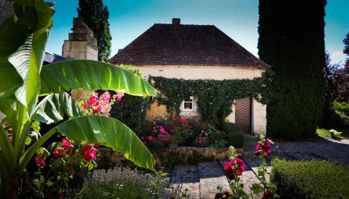 a house with a bunch of flowers in front of it at Studio indépendant ,Manoir de la Vove,Perche in Corbon