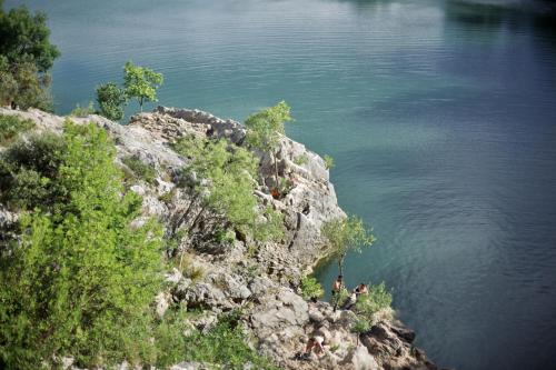 two people standing on a cliff near the water at Hostel Le Diablotin in Saint-Jean-de-Fos