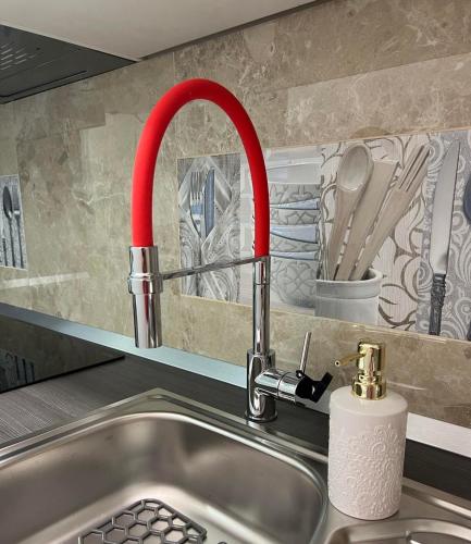 a kitchen sink with a red kitchen faucet at Sweet studio apartment Living in Rijeka in Rijeka