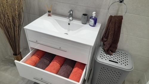 a bathroom with a sink and a drawer with towels at Ramzam - Spacious & Modern 3 bedroom apartment with roof terrace in Marsaskala
