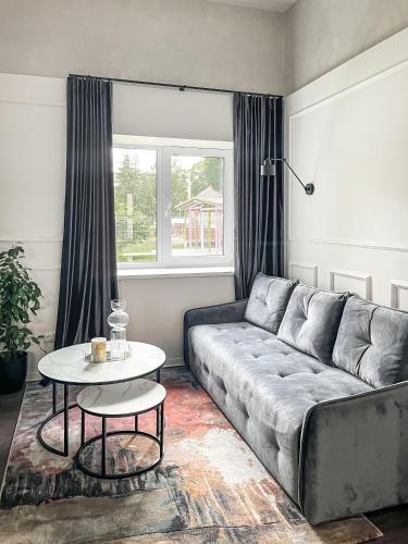 a living room with a couch and a table at Kamurke - Apartamentai in Šiauliai
