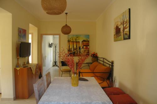 a living room with a table with a vase on it at Maria Apartments in Lefkada Town