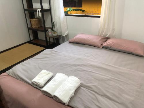a bed with two towels on top of it at Bo Cabin in Garden โบคาบิน อิน การ์เดน in Ban Nong Ki