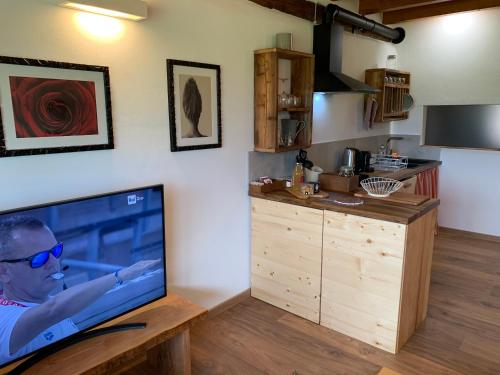 TV en una mesa de madera en la cocina en AGRITURISMO MODOLO Belluno Dolomiti, en Belluno
