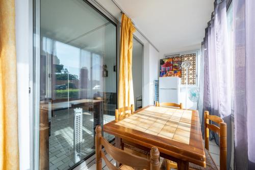 a dining room with a table and a window at Le Tusco in Cap d'Agde