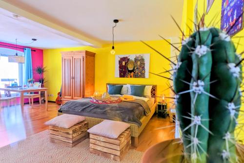 a bedroom with a bed with yellow walls and a cactus at Casa de Pancho - Lateinamerika direkt in der City von Uelzen in Uelzen