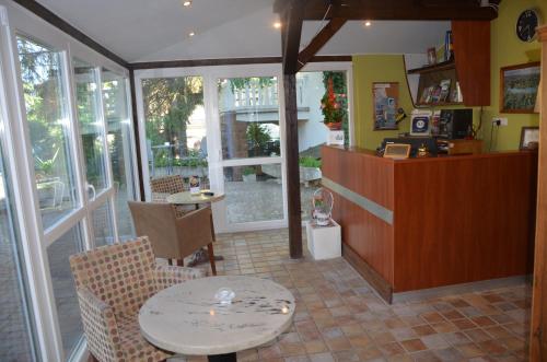 a restaurant with a table and chairs and windows at Hotel Viktória in Balatonalmádi