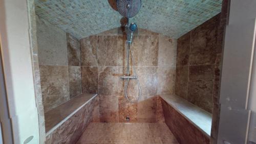 ein Bad mit einer Dusche und einer Badewanne in der Unterkunft Chapel Cottage in La Bachellerie