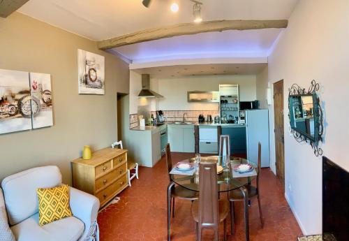 une cuisine et un salon avec une table et des chaises dans l'établissement Le Logis des Cascades 2, à Moustiers-Sainte-Marie