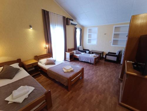 a hotel room with two beds and a living room at Martinović Rooms in Budva