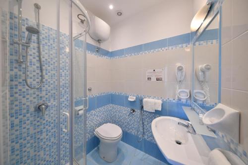 a bathroom with a shower and a toilet and a sink at Hotel Noris in Ischia