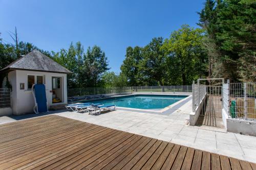 una piscina con terraza de madera y una casa en Château De Razay en Céré-la-Ronde