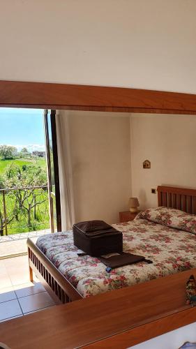 - une chambre avec un lit et une valise dans l'établissement Casa Ciuffina, à Civitella Casanova