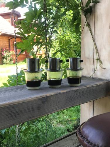 four pots sitting on a wooden shelf on a table at Zagroda w Puszczy in Białowieża