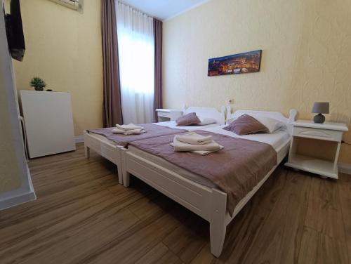 a bedroom with a large bed with towels on it at Martinović Rooms in Budva