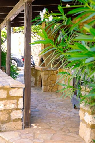 a patio with a stone wall and a bench at Memi Houses in Koroni
