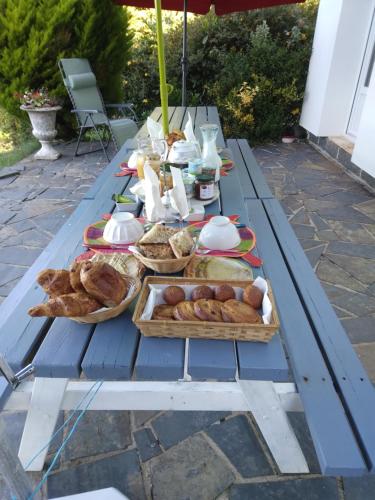 uma mesa de piquenique com pão e bolos em Chambres d'hôtes Saint Quinidic em Meros