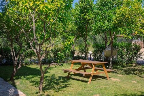 a wooden picnic table in a park with trees at Memi Houses in Koroni