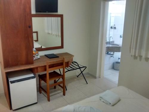 a bathroom with a desk and a mirror and a bed at Regio Plaza Hotel in Ourinhos