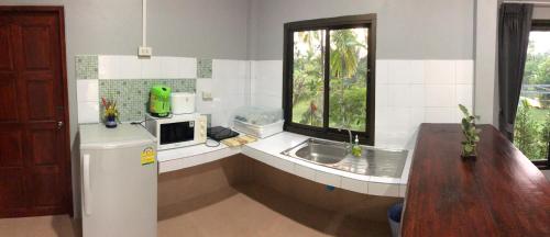 a kitchen with a sink and a microwave at Yangyai Garden Lodge in Baan Tai