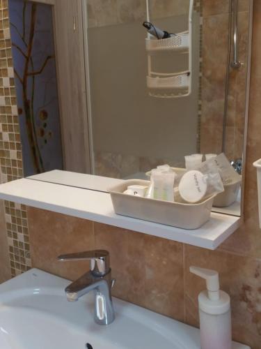 a bathroom with a sink and a mirror at Kalinderu SKIER'S APARTAMENT BELLEVUE in Buşteni
