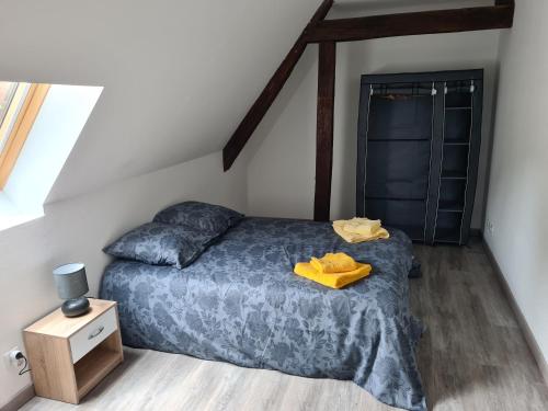 - une chambre avec un lit doté d'un peignoir jaune dans l'établissement Aux remparts du château, à Sedan