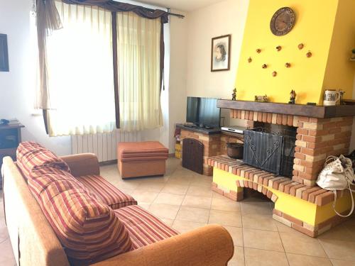 a living room with a couch and a fireplace at B&B Monte Acuto in Cantiano