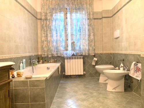 a bathroom with a toilet and a tub and a sink at B&B Monte Acuto in Cantiano