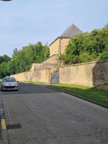 ein Auto fährt eine Straße entlang einer Mauer in der Unterkunft Aux remparts du château in Sedan