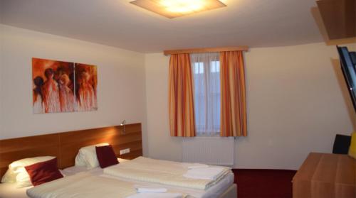 a hotel room with two beds and a window at Beerenhof Wiesen in Mattersburg