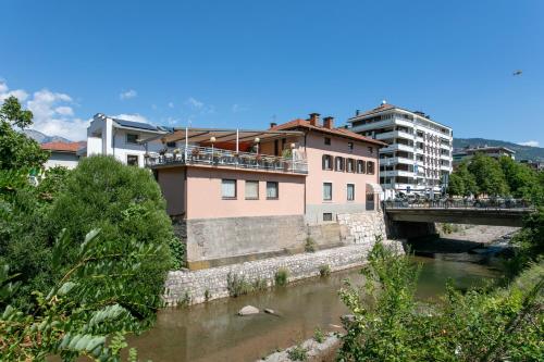 a bridge over a river with people standing on it at Appartamento grande Al Ponte. Situato vicino all'ospedale, al parco e al centro città in Trento