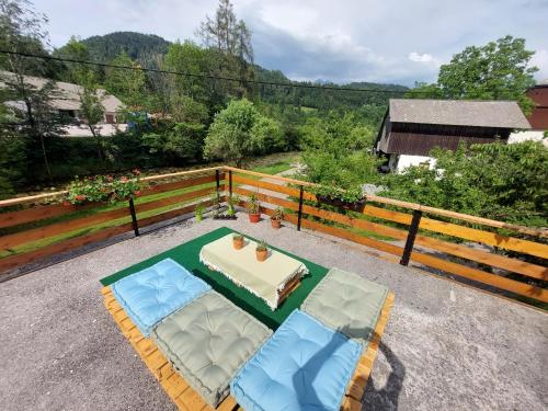 un patio con mesa, 2 sillas y una mesa en The RiverSide Chill Hostel en Bled