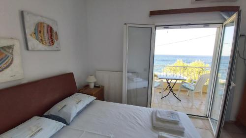 a bedroom with a bed and a view of the ocean at Breezy Beach House in Agia Marina Mikrolimanou