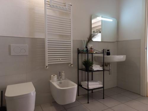 bagno bianco con lavandino e servizi igienici di Room 28 a Ferrara