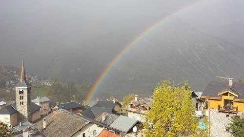 a rainbow over a city with a town with buildings at appartement Ancolie in Saint-Martin-de-Belleville