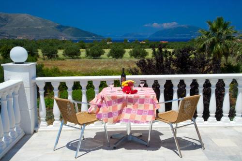 a table on a balcony with a table and chairs at Nikos Studios and Apartments in Sami