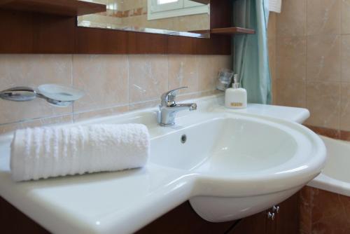 un lavandino in bagno con un asciugamano bianco di Stunning Seaview Estate by Keyplanner a Evropoúloi