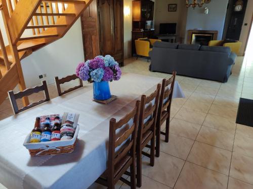 einen Tisch mit Getränken und eine Vase Blumen in der Unterkunft Les Gites de TY Dreux Monts d'arrée in Saint-Thégonnec