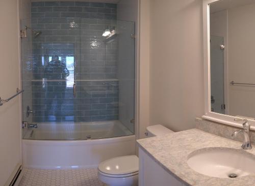 a bathroom with a shower and a toilet and a sink at The Sullivan House in New Shoreham