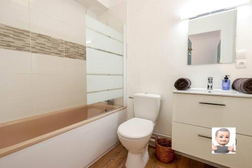 a bathroom with a toilet and a tub and a sink at Le petit Park-studio-terrasse- piscine-WIFI FIBRE in Pau