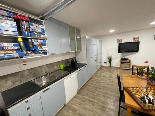 慕尼黑的住宿－Homestay Manolov，厨房配有水槽、桌子和电视。