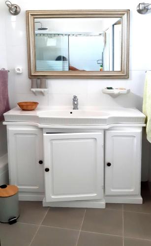 une salle de bain avec un lavabo blanc et un miroir dans l'établissement La Forgeolie, à Causses-et-Veyran