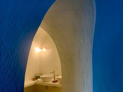 a bathroom with a white sink and a blue wall at White Curves Santorini in Akrotiri