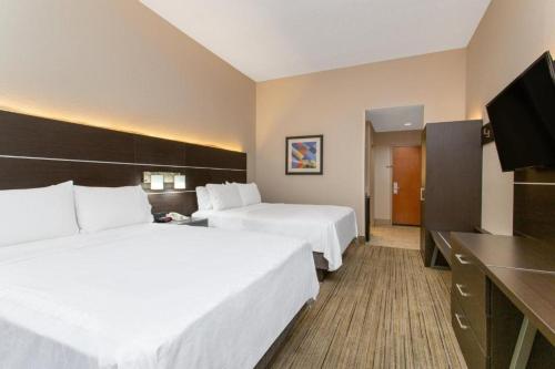 a hotel room with two beds and a flat screen tv at Holiday Inn Express Silver Springs - Ocala by IHG in Silver Springs