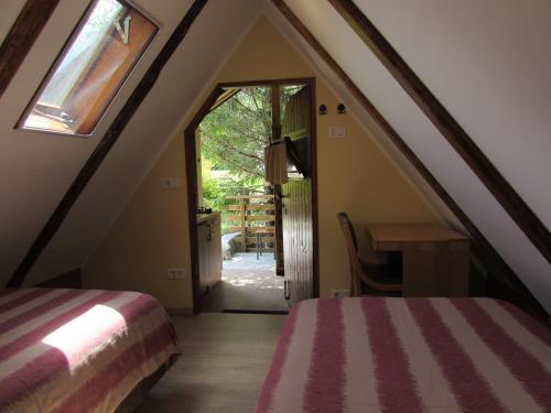 ボヴェツにあるGlamping Narniaのベッドとテーブル付きの屋根裏部屋