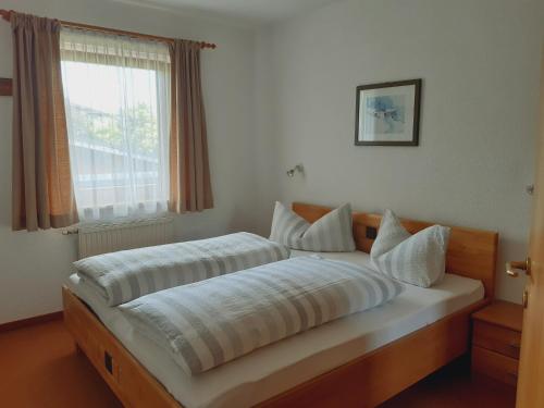 sypialnia z 2 łóżkami i oknem w obiekcie Appartementhaus St. Martin w mieście Seefeld in Tirol