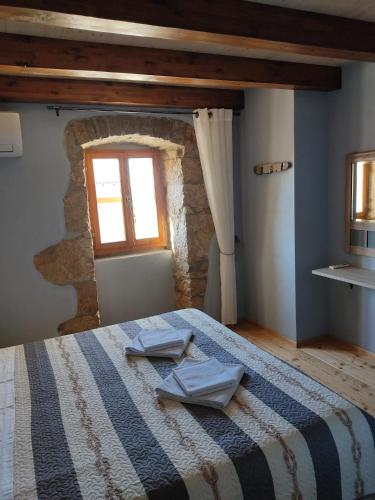 a bedroom with a bed with two towels on it at House Tuna in Ustrine