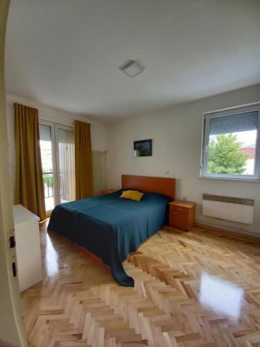 - une chambre avec un lit bleu et du parquet dans l'établissement Katerina Apartment, à Ohrid